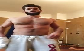Cute muscular bearded guy doing a solo in front of the web cam